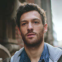 portrait of a man with short brown hair and stubble