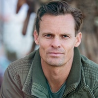 portrait of a man with short brown hair in a green jacket